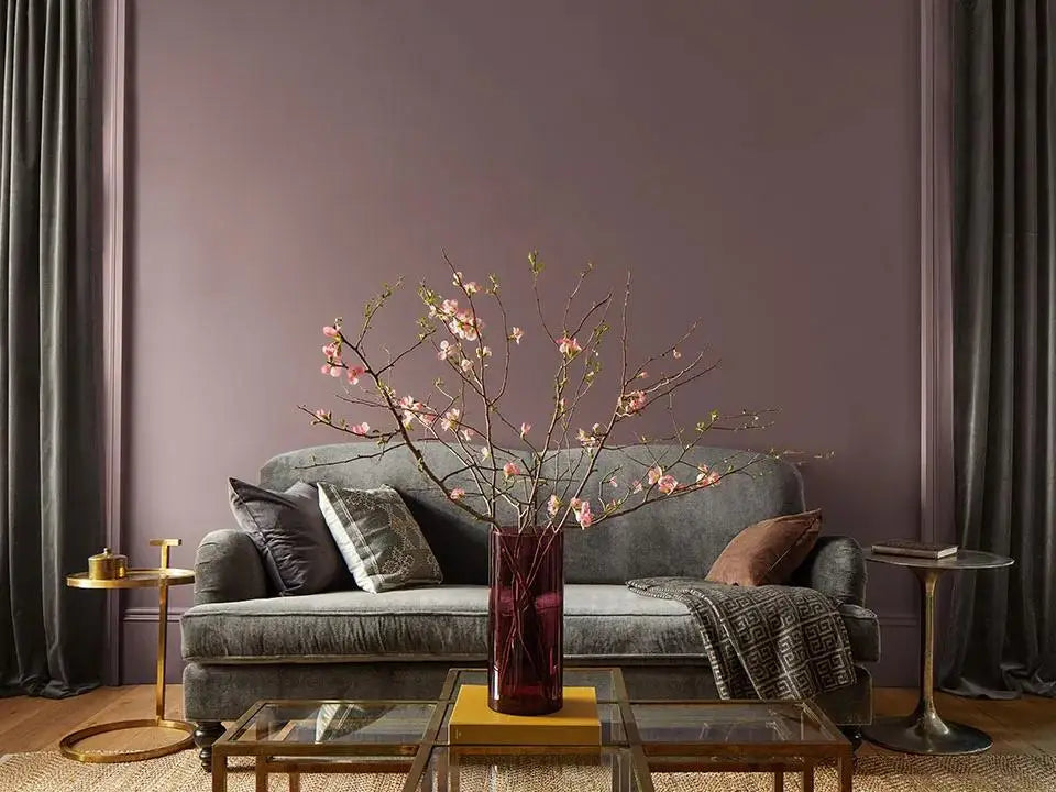 Elegant gray sofa with pillows and blanket, highlighting the warmth of Benjamin Moore Cinnamon Slate.