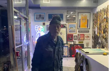 Man in dark cap and jacket at doorway celebrating Hasbrouck Heights National William Day.