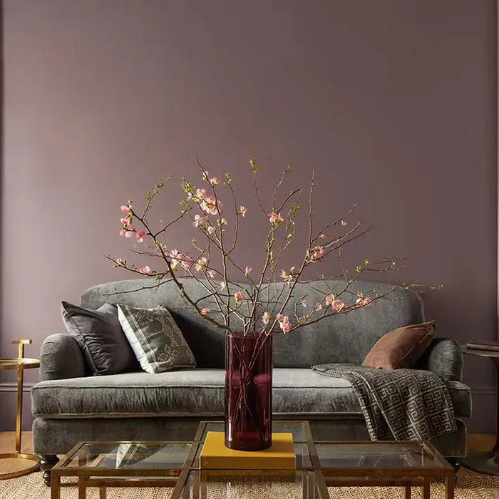 Elegant gray sofa with pillows and blanket, highlighting the warmth of Benjamin Moore Cinnamon Slate.