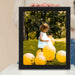 a person holding a picture of a child surrounded by balloons