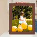 a person holding a picture frame with a picture of a little girl surrounded by balloons