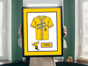 a person holding a framed picture of a baseball uniform