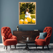 a little girl sitting in a chair with balloons