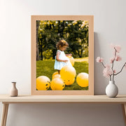 a picture of a little girl in a blue dress surrounded by yellow balloons